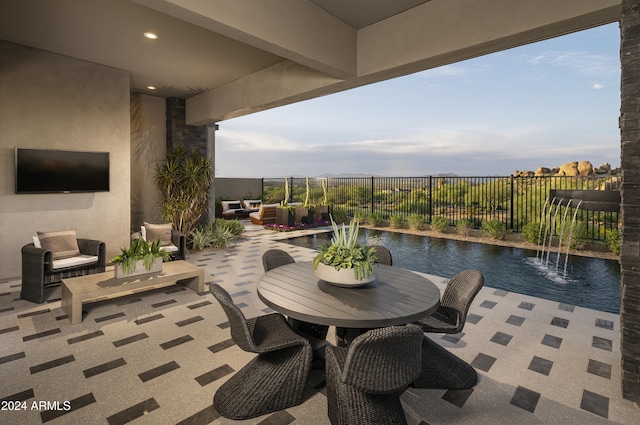 view of patio featuring a fenced in pool, pool water feature, a water view, and an outdoor hangout area