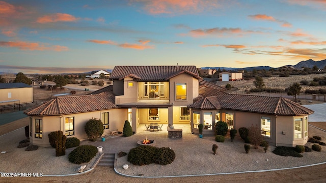 view of front of property featuring a patio, a mountain view, and a fire pit