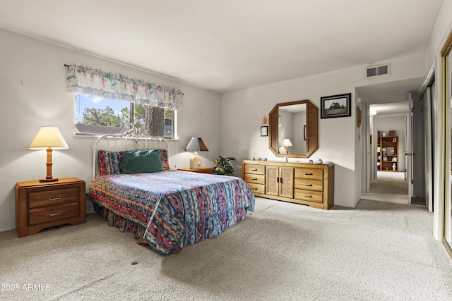 carpeted bedroom featuring visible vents