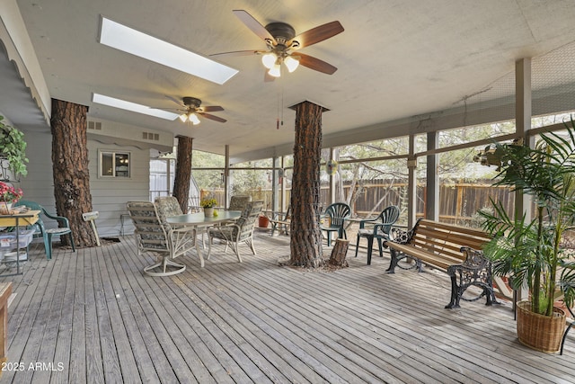 wooden terrace with ceiling fan, visible vents, fence, and outdoor dining area