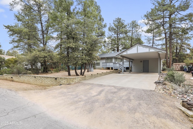 view of front facade with a carport, fence, and concrete driveway