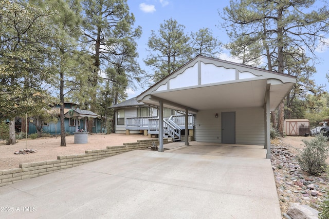 view of front of property with driveway, a carport, and an outbuilding