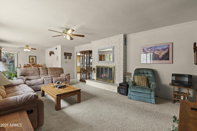 carpeted living room featuring a brick fireplace, crown molding, a ceiling fan, and a textured ceiling