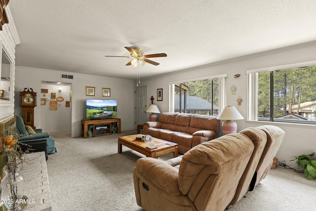 living area with a glass covered fireplace, visible vents, carpet flooring, and a textured ceiling