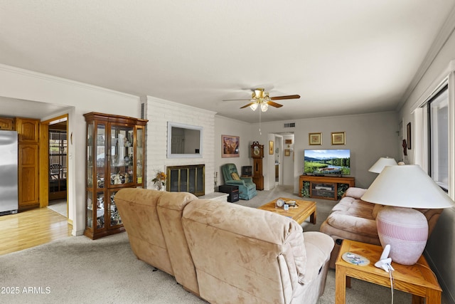 living area with ornamental molding, a wealth of natural light, a brick fireplace, and visible vents