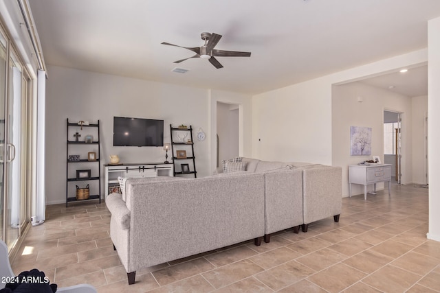 living room with a wealth of natural light, ceiling fan, and light tile patterned flooring