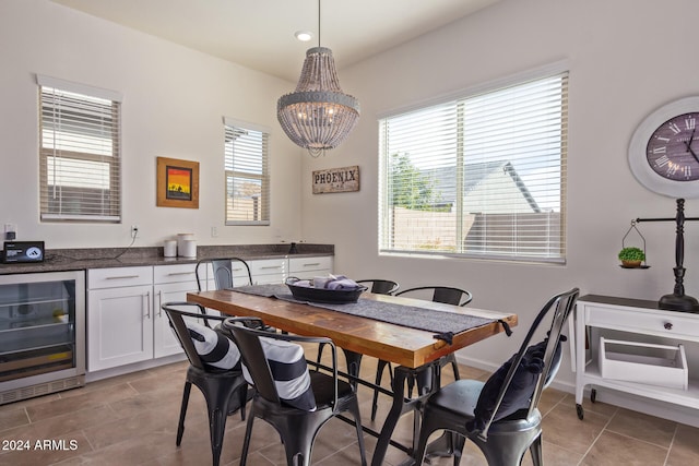 dining space with light tile patterned floors, an inviting chandelier, plenty of natural light, and beverage cooler