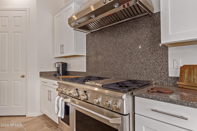 kitchen with white cabinets, light tile patterned floors, high end range, and range hood