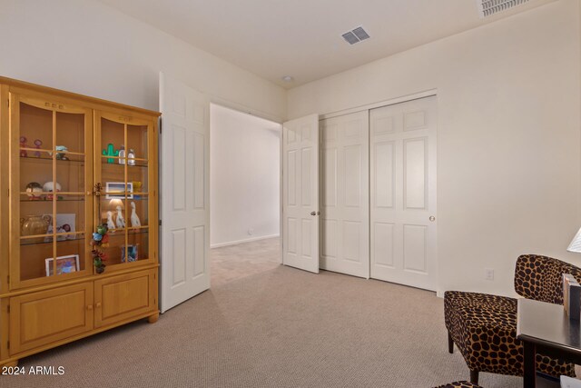 living area featuring light carpet