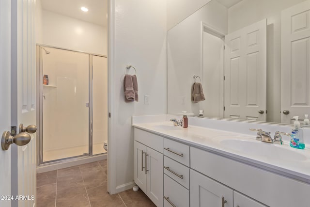 bathroom with tile patterned floors, toilet, vanity, and walk in shower