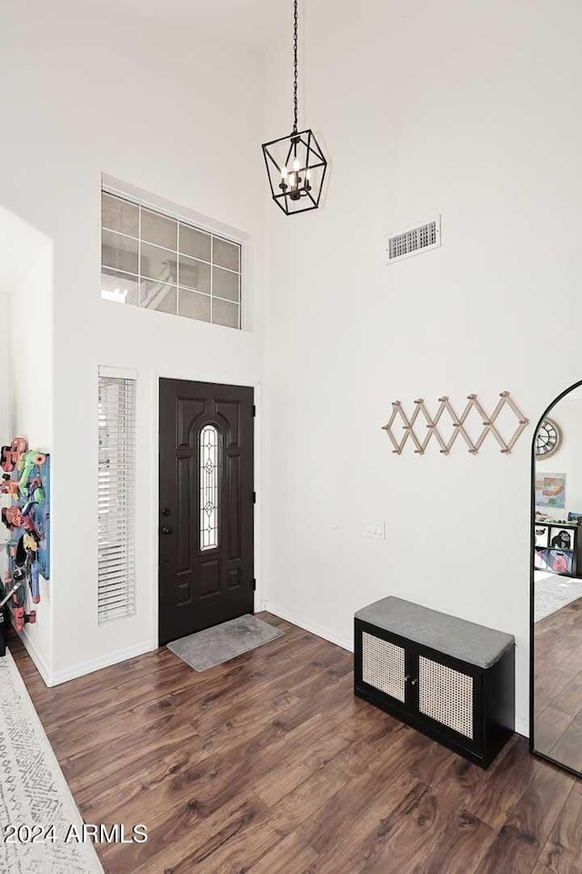 entrance foyer featuring dark hardwood / wood-style flooring, a high ceiling, and a chandelier