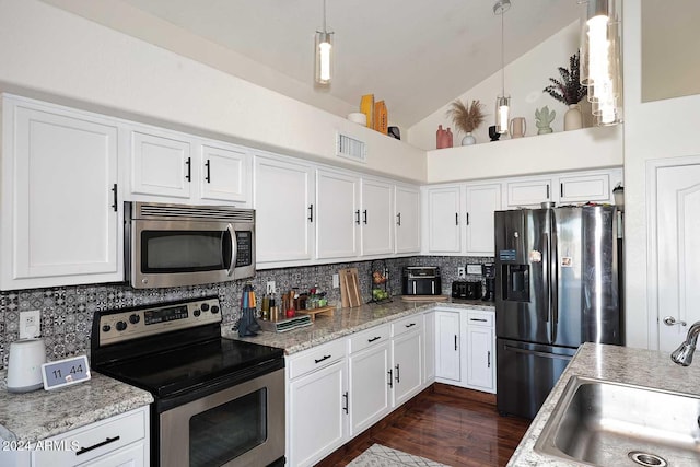 kitchen with appliances with stainless steel finishes, sink, high vaulted ceiling, and decorative light fixtures