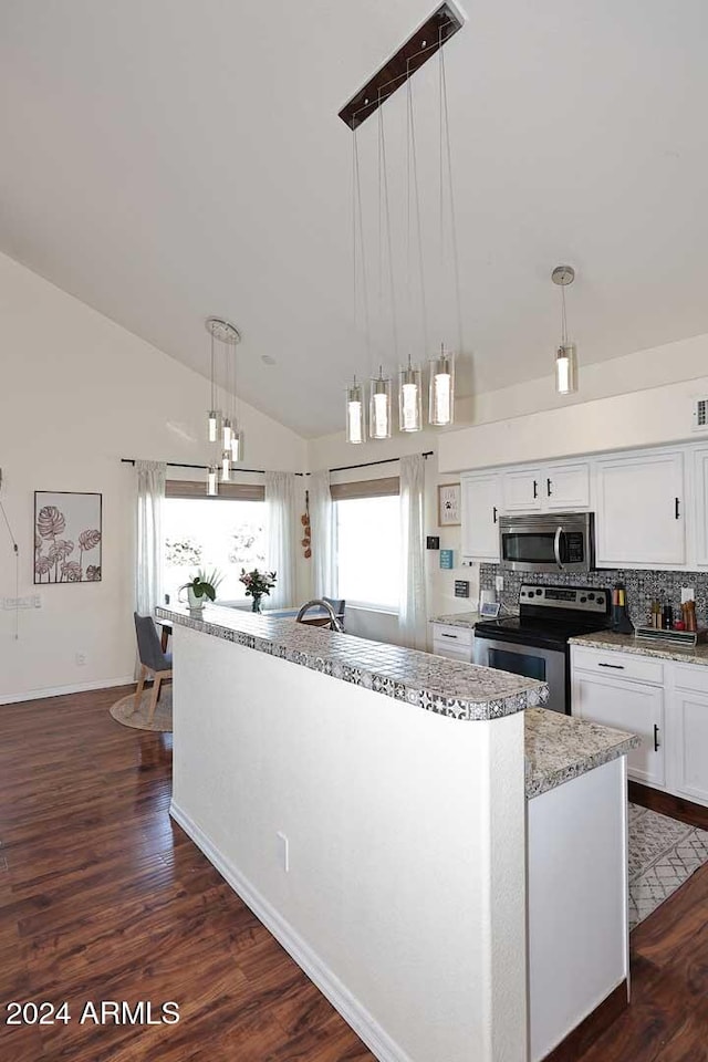 kitchen featuring appliances with stainless steel finishes, white cabinets, hanging light fixtures, and high vaulted ceiling