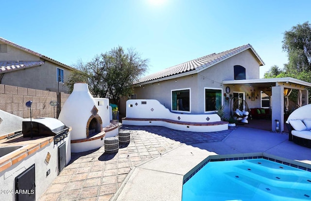 exterior space with an outdoor fireplace, an outdoor kitchen, and a patio area