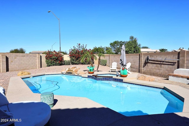 view of pool with a patio area and an in ground hot tub