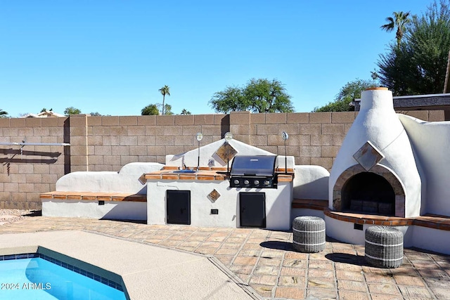 view of patio featuring an outdoor fireplace and area for grilling