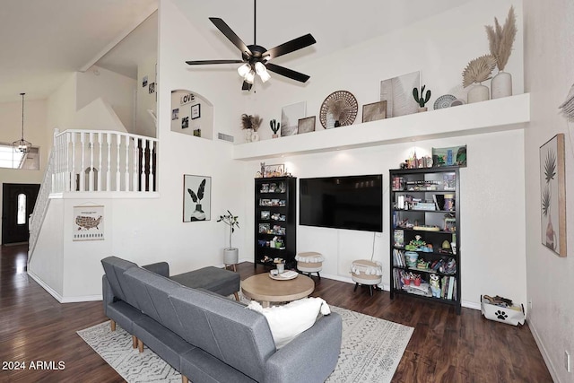 living room featuring ceiling fan, dark hardwood / wood-style floors, and a high ceiling