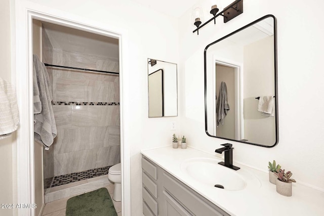 bathroom with toilet, tile patterned flooring, walk in shower, and vanity