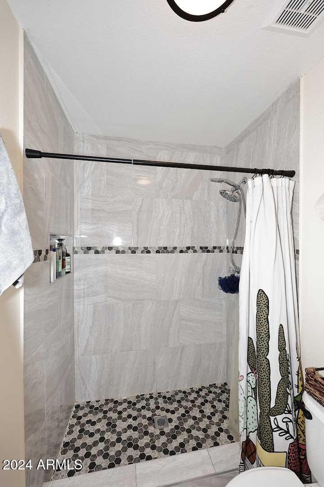 bathroom featuring toilet and a shower with shower curtain