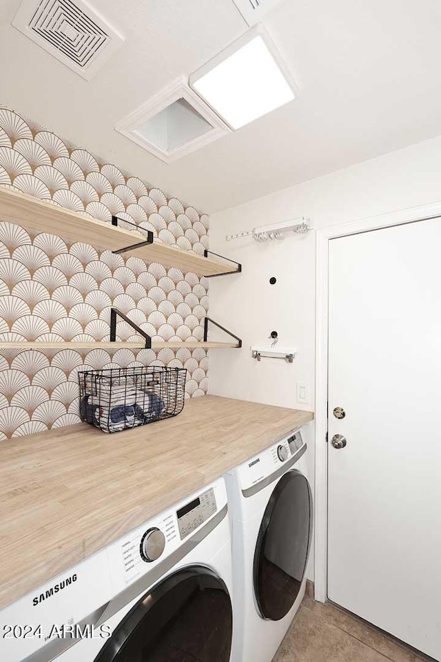 washroom featuring washing machine and dryer and light tile patterned floors