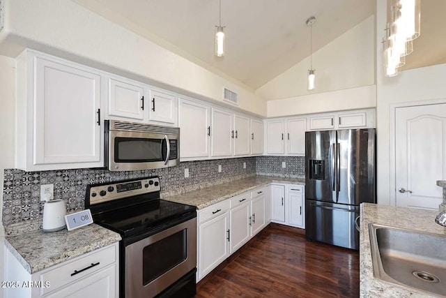 kitchen featuring decorative backsplash, sink, white cabinetry, hanging light fixtures, and appliances with stainless steel finishes