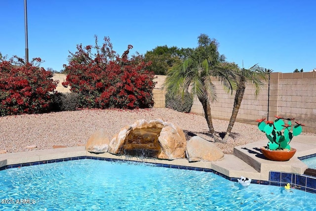 view of swimming pool with pool water feature