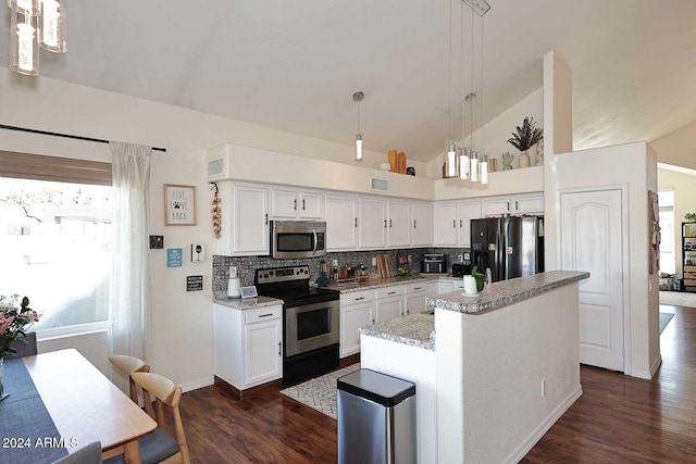 kitchen featuring pendant lighting, appliances with stainless steel finishes, a kitchen island, white cabinetry, and decorative backsplash