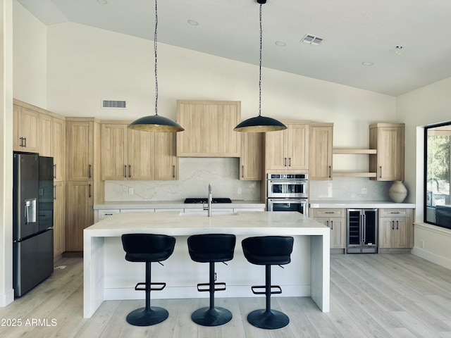 kitchen with tasteful backsplash, black refrigerator with ice dispenser, sink, light brown cabinets, and beverage cooler