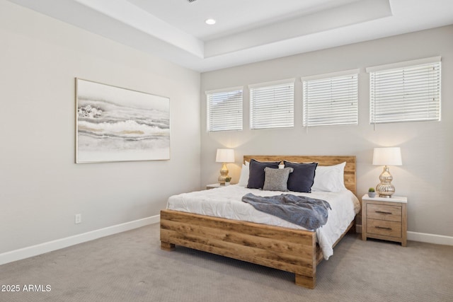 bedroom with recessed lighting, a tray ceiling, carpet floors, and baseboards