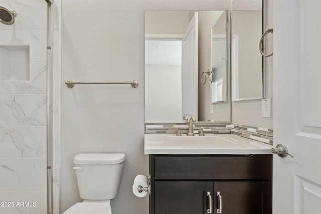 bathroom featuring a shower, decorative backsplash, toilet, and vanity