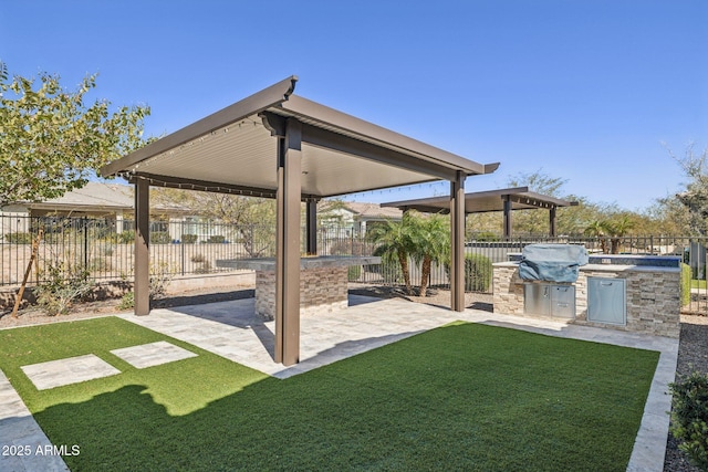 view of yard with an outdoor kitchen, a patio, and a fenced backyard