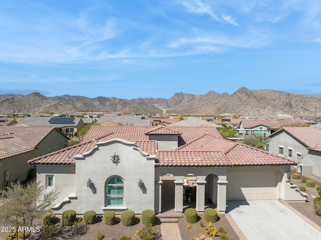 mediterranean / spanish-style home featuring stucco siding, a mountain view, and a tile roof