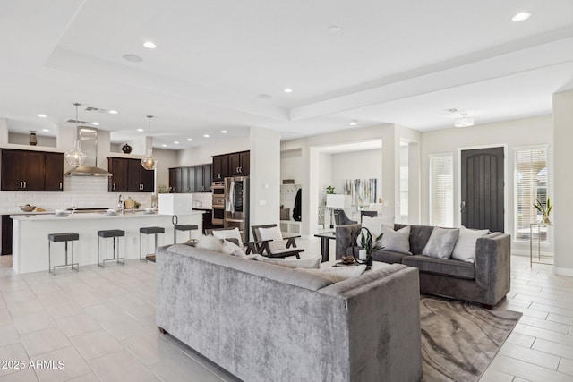 living room with a raised ceiling and recessed lighting