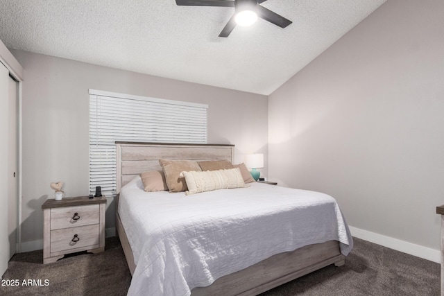 bedroom featuring a textured ceiling, a closet, dark carpet, and ceiling fan