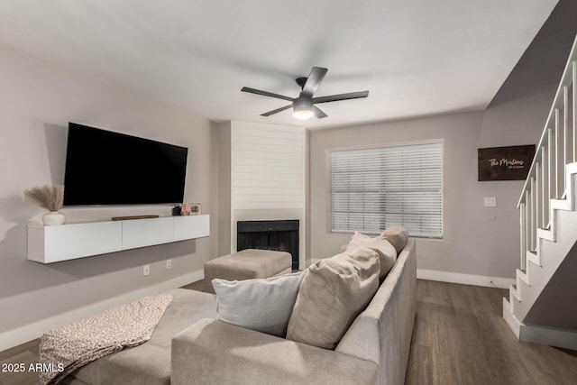 living room with ceiling fan, a large fireplace, and hardwood / wood-style floors