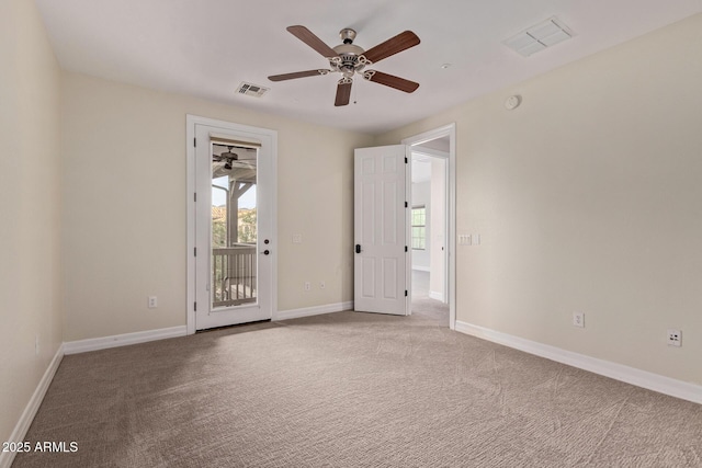 spare room featuring carpet, visible vents, and baseboards