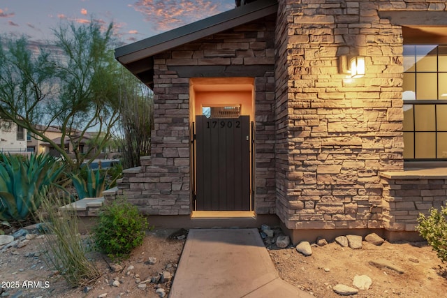 view of exterior entry featuring stone siding