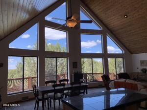 dining space featuring high vaulted ceiling, wooden ceiling, and a ceiling fan