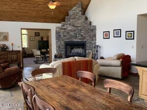 dining space with a fireplace, vaulted ceiling, and wooden ceiling
