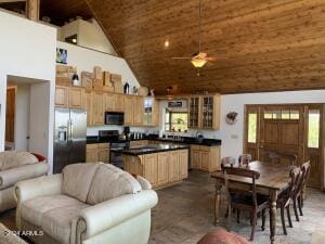 kitchen with high vaulted ceiling, a kitchen island, glass insert cabinets, stainless steel appliances, and dark countertops