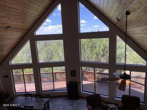 living room with expansive windows, high vaulted ceiling, ceiling fan, and wood ceiling