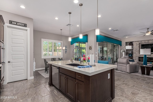 kitchen featuring a center island with sink, hanging light fixtures, sink, ceiling fan, and appliances with stainless steel finishes