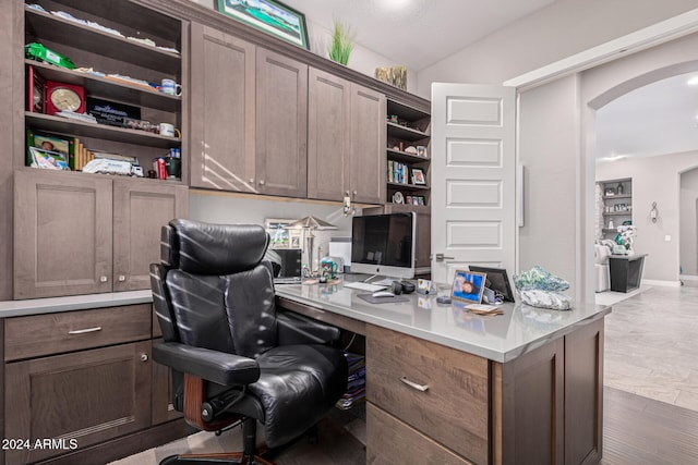 home office featuring light wood-type flooring and built in desk