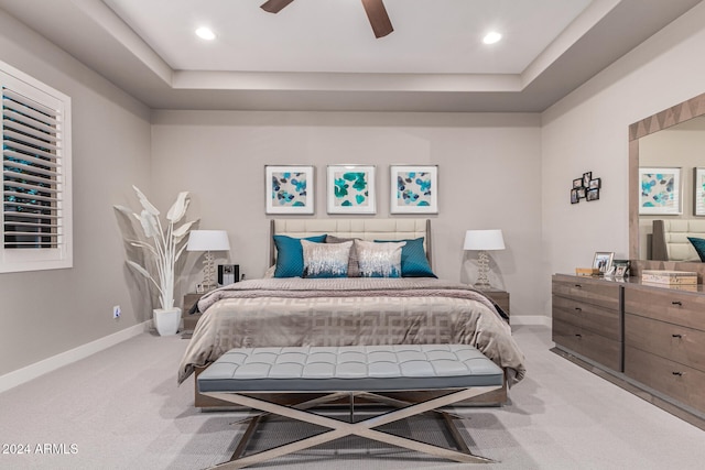 carpeted bedroom featuring a raised ceiling and ceiling fan