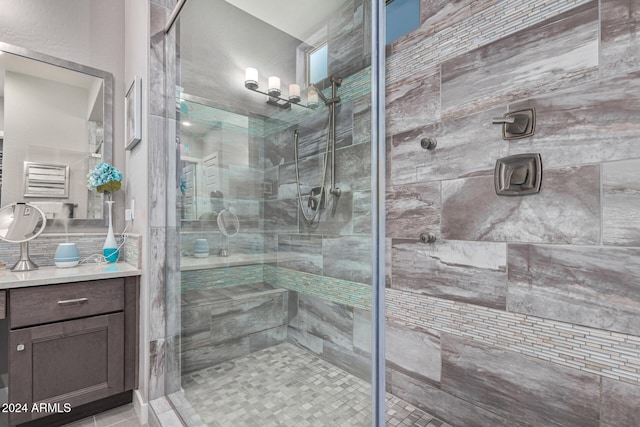 bathroom with tile patterned flooring, vanity, and walk in shower