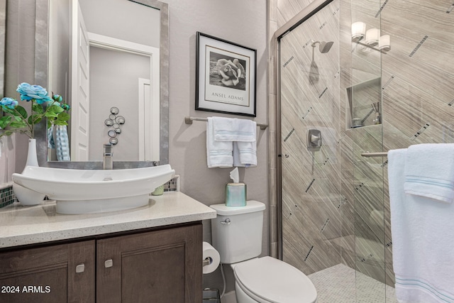 bathroom with an enclosed shower, vanity, and toilet