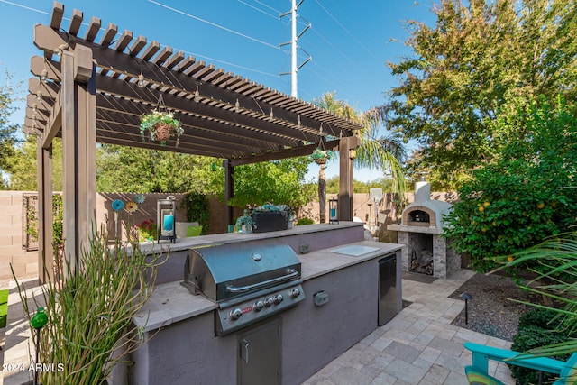 view of patio with a pergola, area for grilling, a grill, and an outdoor stone fireplace