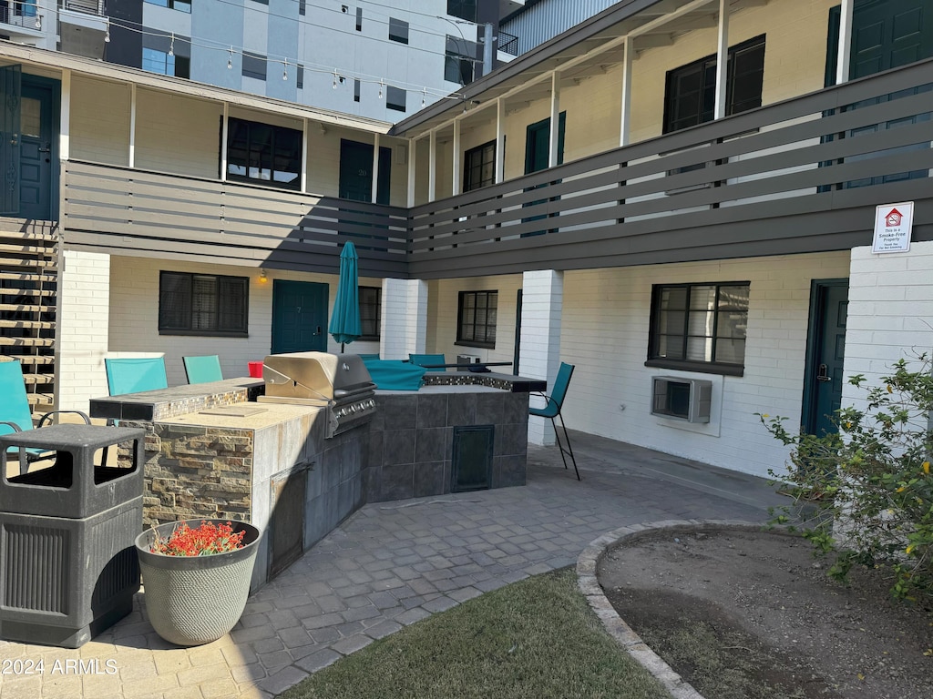 view of patio with area for grilling and a balcony