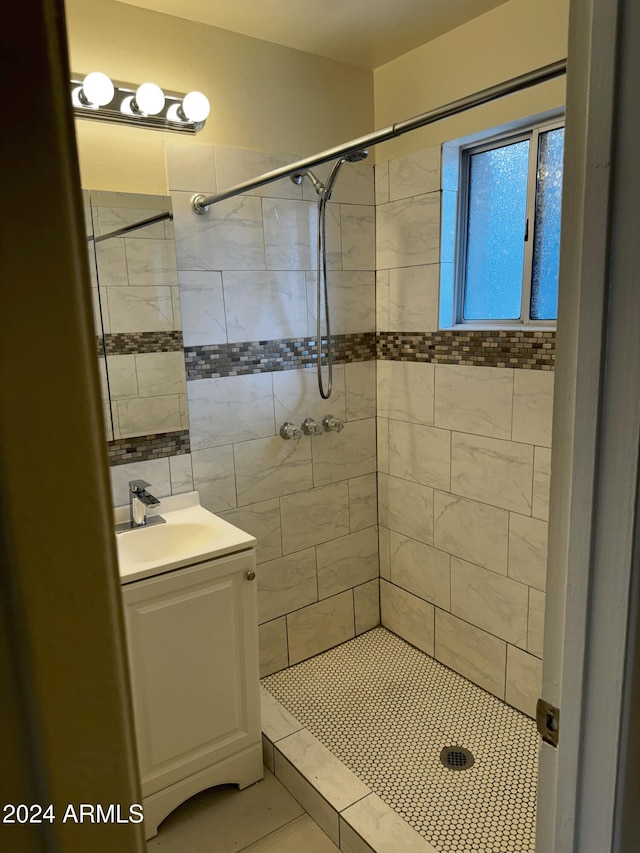 bathroom featuring vanity, a tile shower, and tile patterned floors