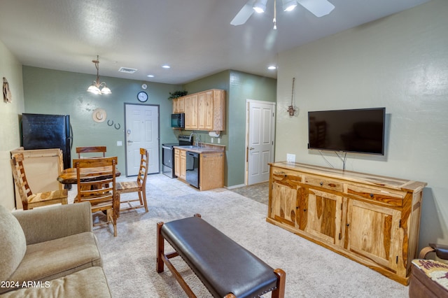 carpeted living room with sink and ceiling fan with notable chandelier